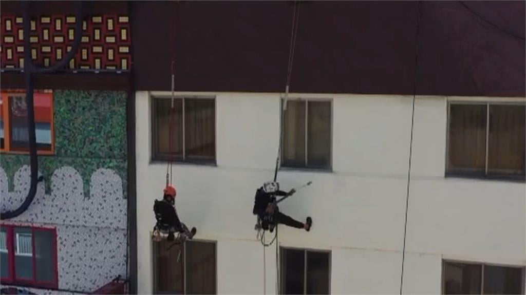 利用「繩索吊掛」進行防水作業　工程人員如「蜘蛛人」隨風擺盪