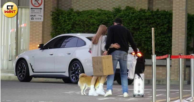 小情侶緊摟在一起，禹菡牽著愛犬，而男方拖著行李箱準備放到後車箱。（圖／本刊攝影組）