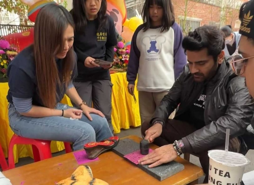 印度男神阿建來台宣傳《叫我驅魔男神》入境隨俗「體驗打小人」，拿鐵槌猛打超認真。（圖／光盛影業）&nbsp;