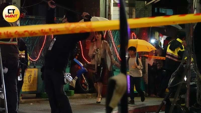 柯佳嬿在低溫中穿著單薄,撐著雨傘緊牽劇中小兒子,在雨中神情焦慮地穿梭。(圖/本刊攝影組)