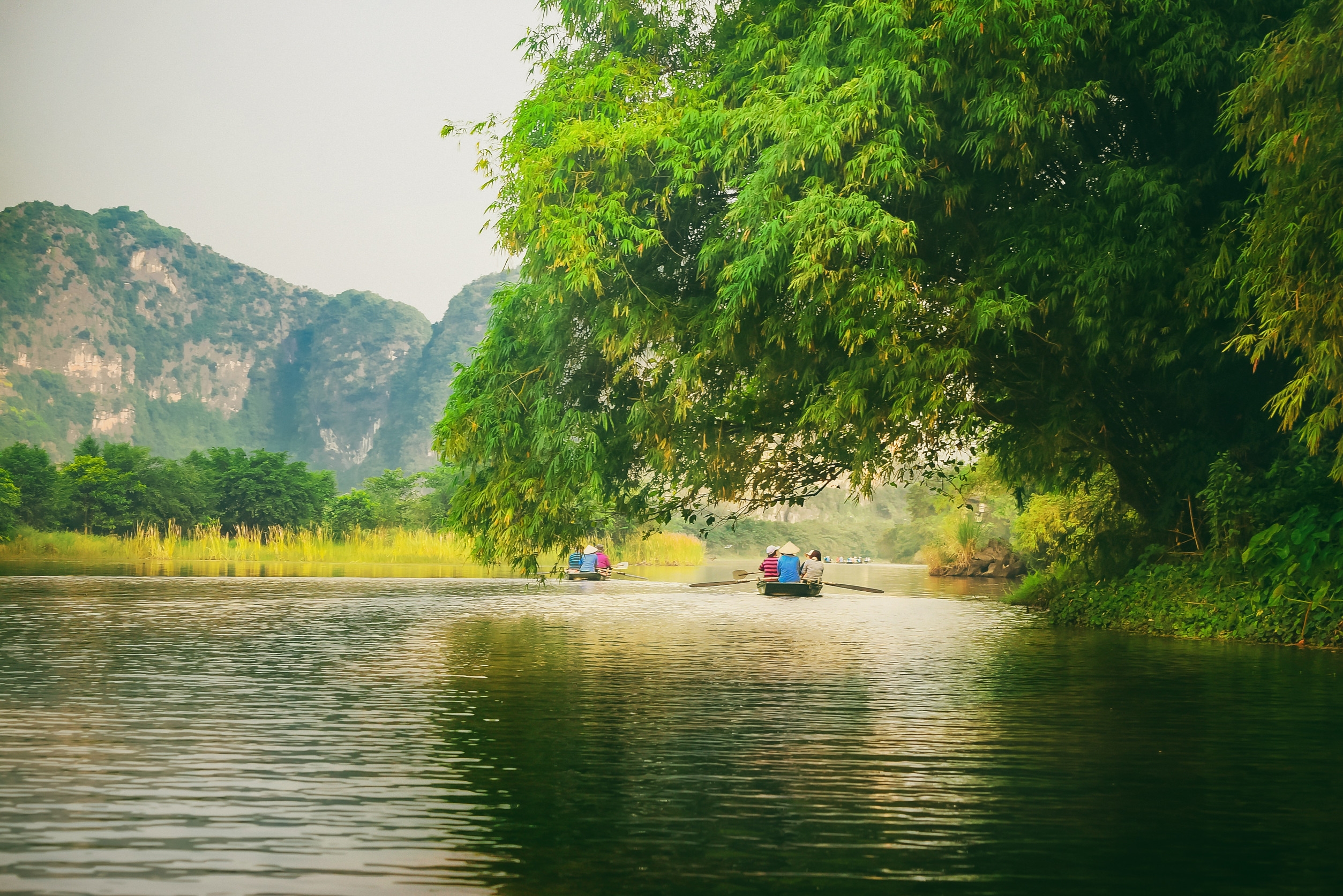 越南寧平當地渡假村融入了古城文化，妳可以搭乘小船划過靜謐的河道，看著岸邊的石灰岩山丘發呆。圖/123RF圖庫