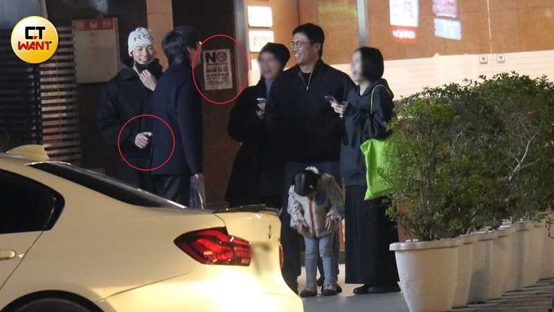 許光漢手持加熱菸，準備拉下口罩吞雲吐霧，身後牆上剛好貼著禁菸警語。（圖／本刊攝影組）