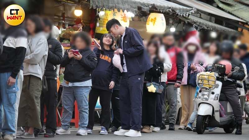 抵達小吃店外，夫妻倆邊排隊邊聊天。（圖／本刊攝影組）