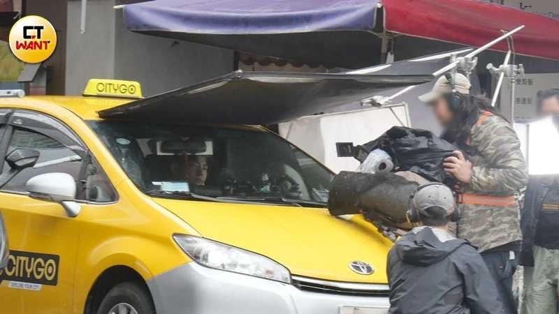 因酒駕遭吊扣駕照的王柏傑,在《老子》中竟演出小黃運將。劇組為力保他,及讓他合法完成演出,出動多位穿著雨衣的工作人員,上演「人力計程車」。(圖/攝影組)