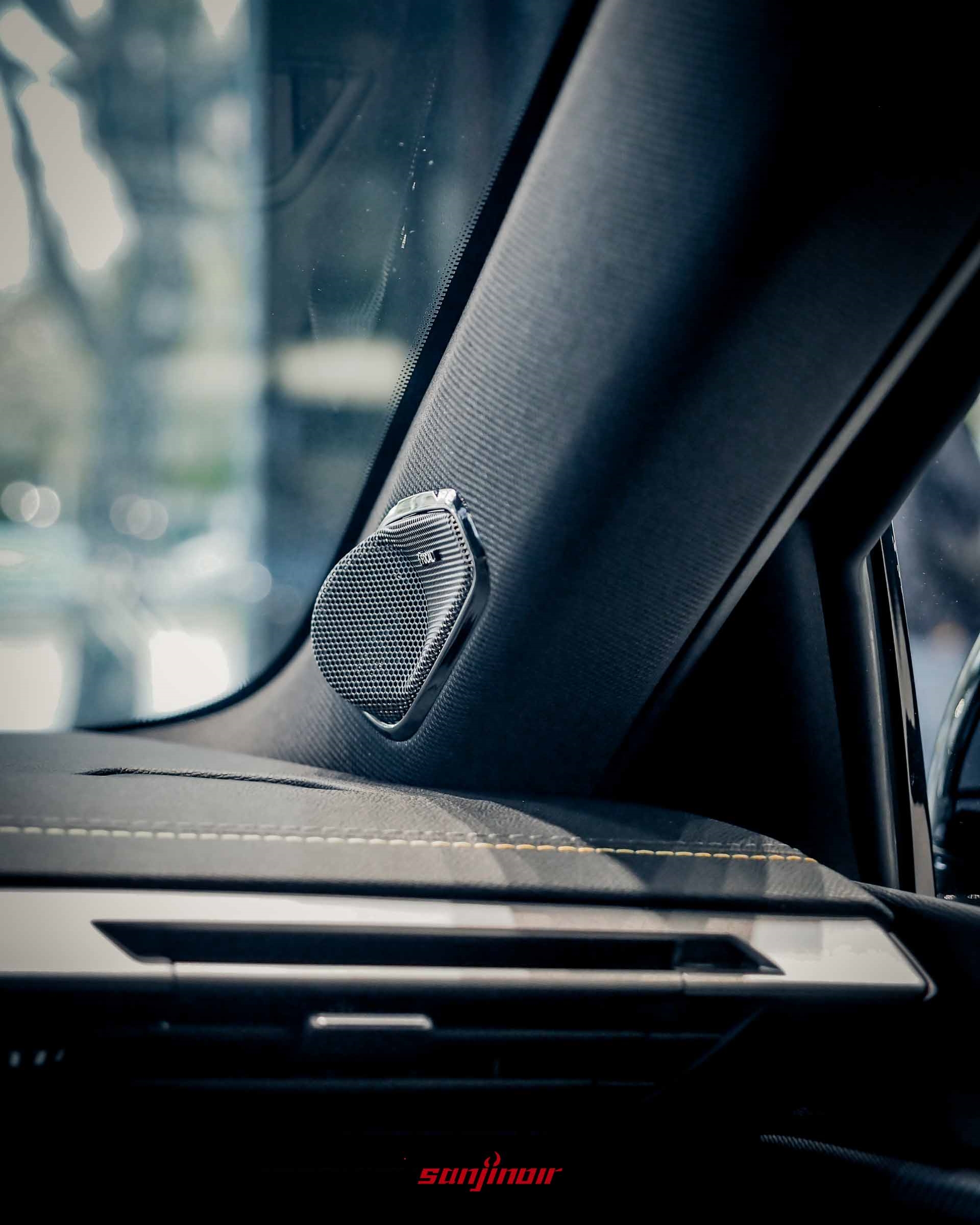 一輛 PEUGEOT 408 內部的 A 柱特寫。一個帶有金屬網罩的揚聲器安裝在黑色 A 柱裝飾板上。網罩中央有「FOCAL」標誌。