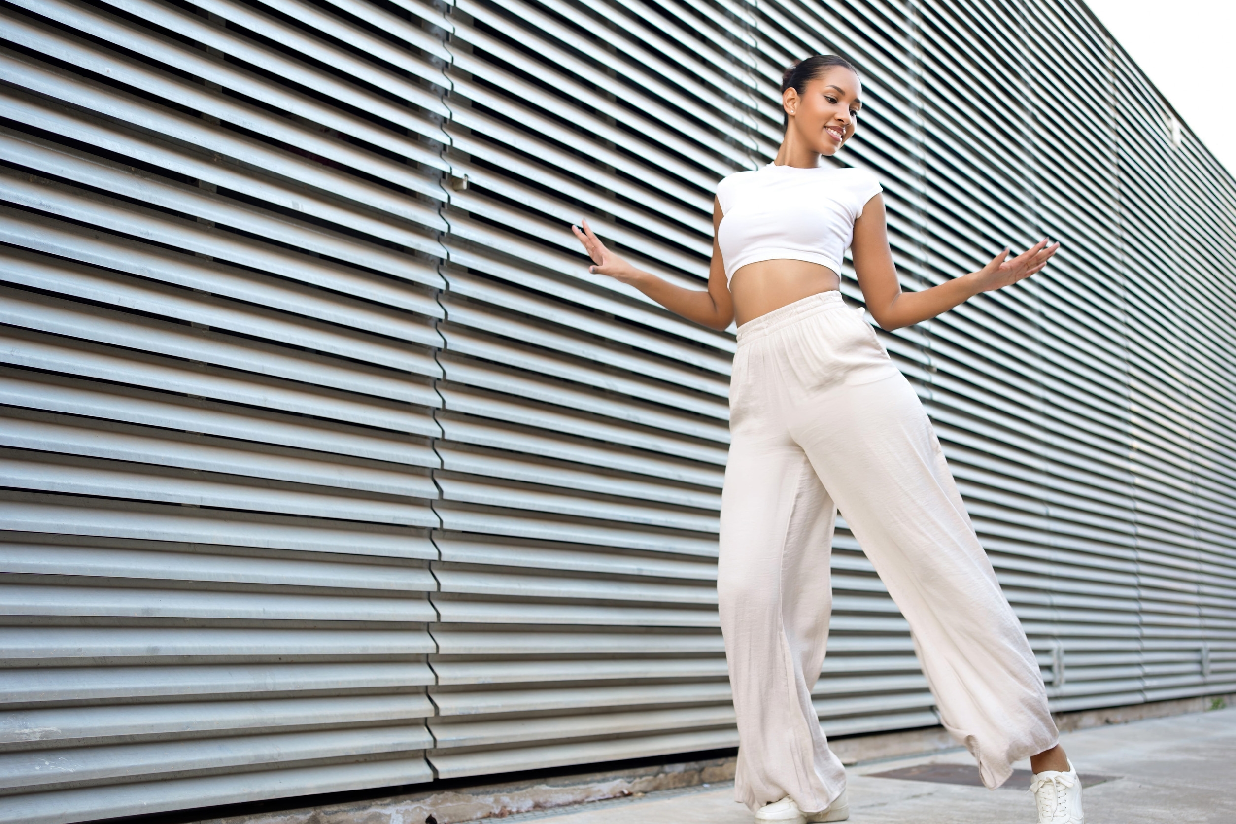 選擇一件貼身的短版背心或削肩上衣，大方露出相對纖細的肩頸線條。當視覺重點停留在纖細的上半身，運動寬褲的垂墜感就能順勢掩蓋下半身的肉肉。圖/123RF圖庫