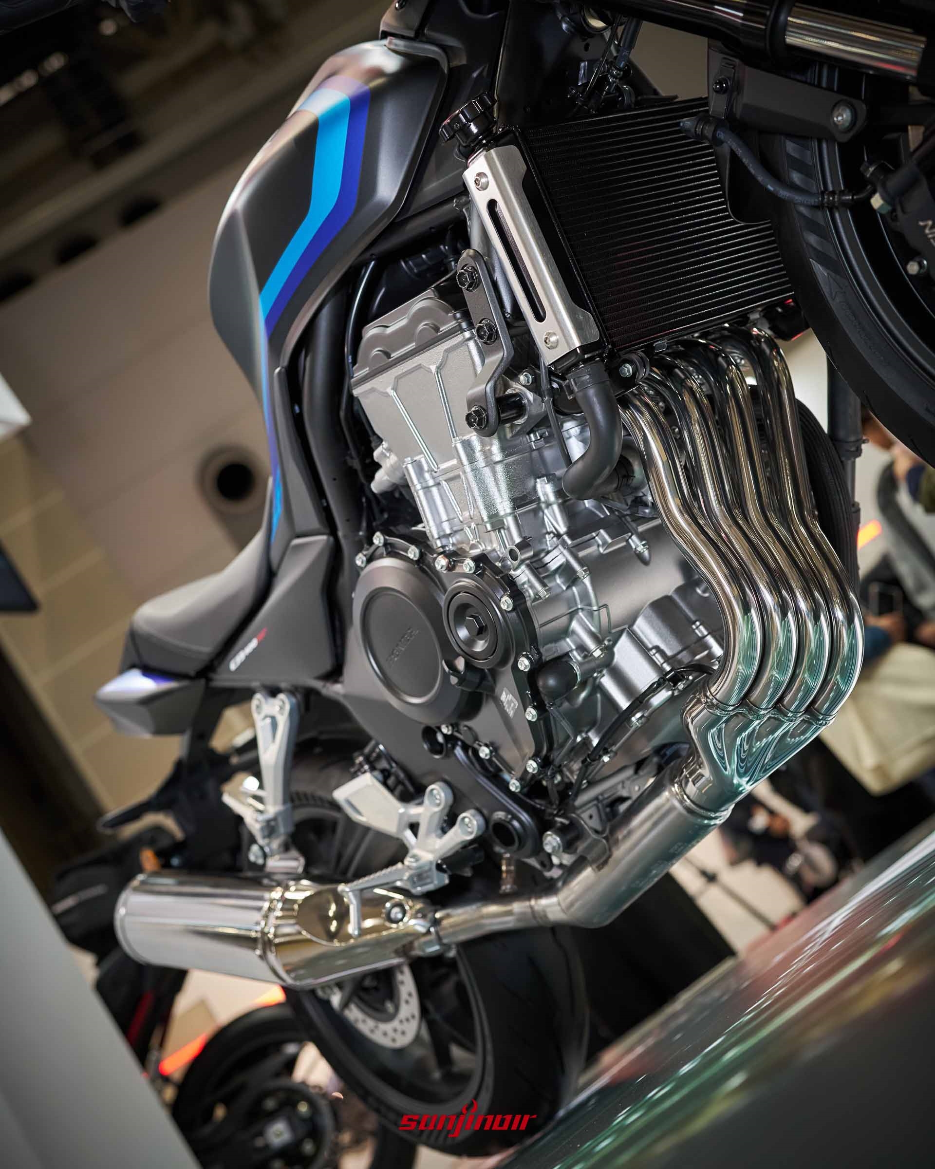 由側下視角拍攝的Honda CB400SF引擎本體與側排氣管，展現緊湊的四缸結構。