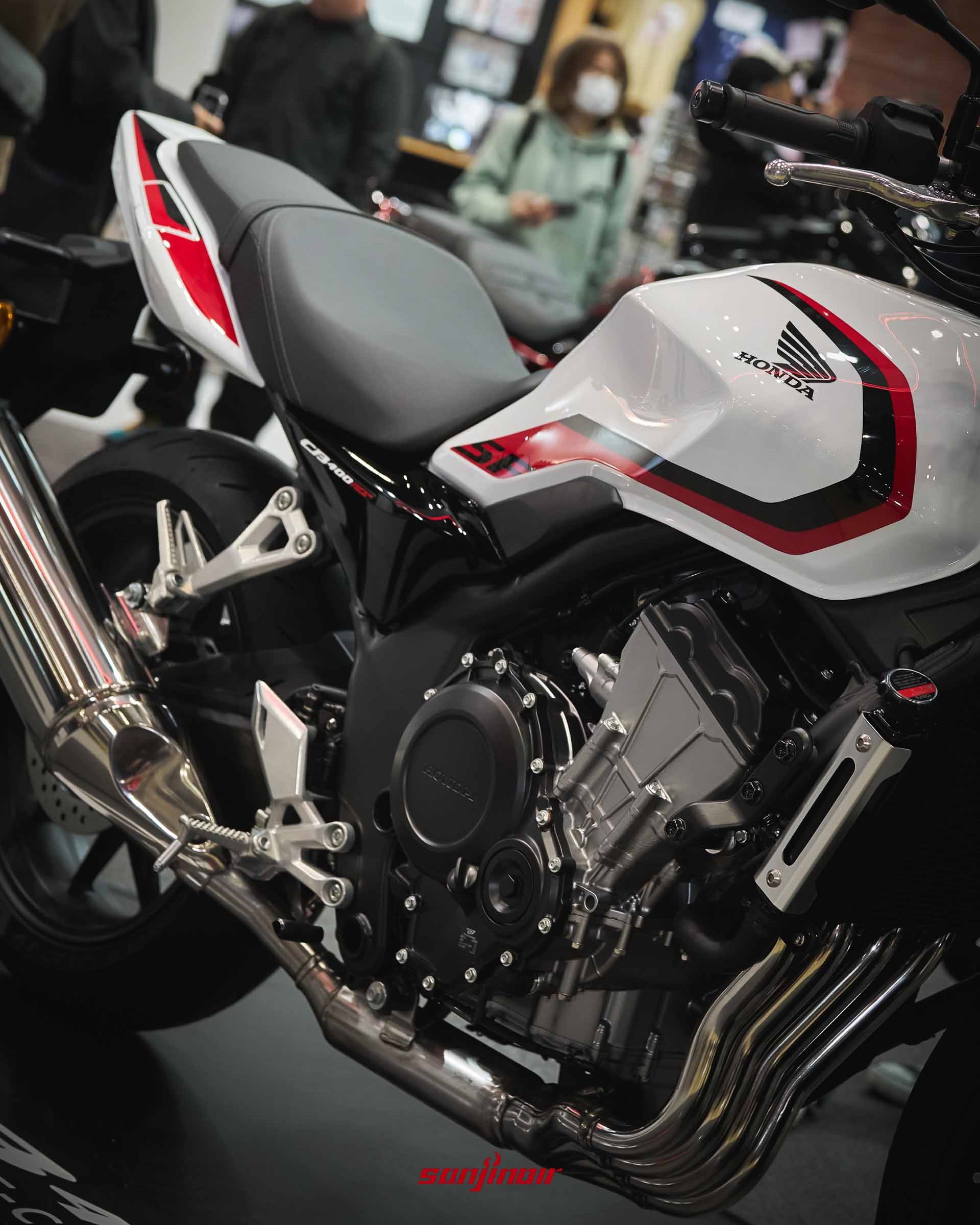 白紅塗裝的Honda CB400 Super Four側面特寫，展示油箱線條與引擎輪廓。