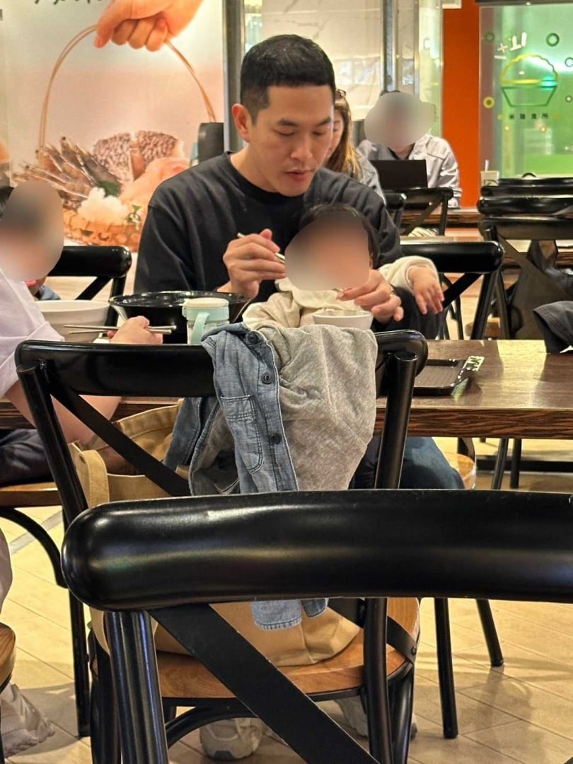 阿奎一邊吃飯一邊餵女兒，看起來相當熟練。（圖／讀者提供）