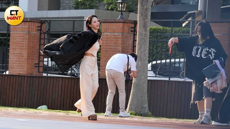 孫淑媚穿著白色小背心白長褲拍私服美照,還把碩士袍當作披風般帥氣搭在肩上。(圖/本刊攝影組)