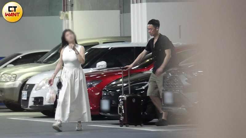 張承中開車到達板橋某知名飯店停車場，停好車後兩人下車，張承中繼續替女方推著行李箱，肩上還多了一個雙肩背包，女方則拎著夜市美食戰利品。（圖／本刊攝影組）
