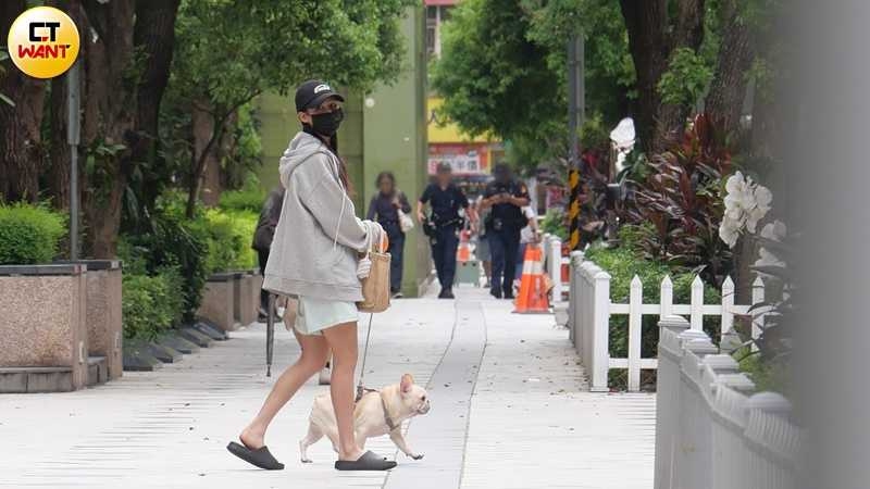 講完電話後,她牽著愛犬「木木」出門散步並至超商買咖啡,在店外等待時,她眼神空洞、若有所思。(圖/本刊攝影組)